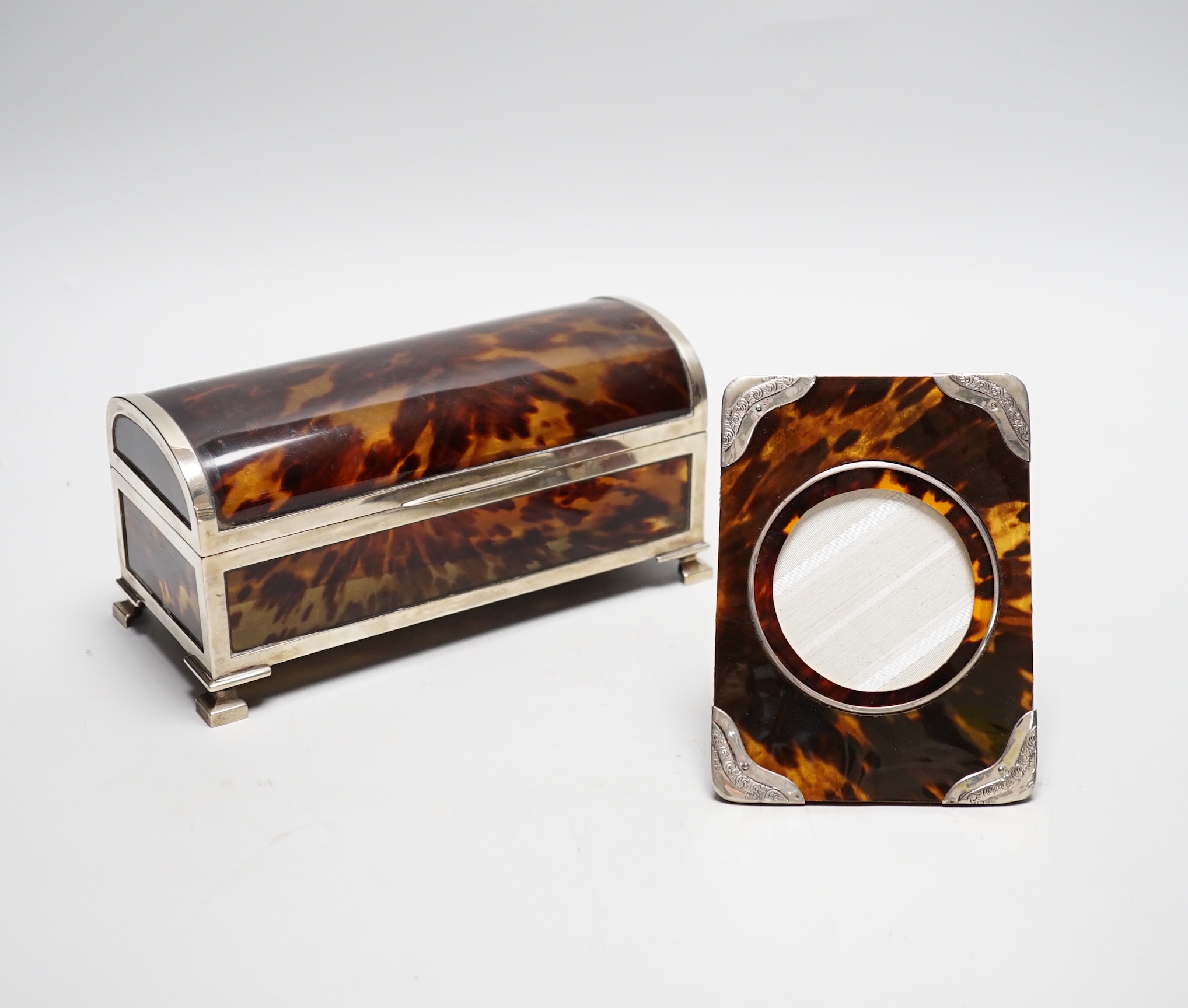 A George V silver mounted tortoiseshell domed top jewellery casket (a.f.) J.Batson & Sons, London, 1916, retailed by Asprey, London, 19.6cm, together with a small Edwardian silver mounted tortoiseshell photograph frame.